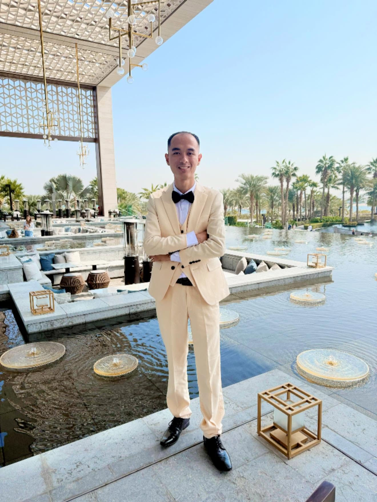 Athika in a cream tuxedo at an outdoor terrace
